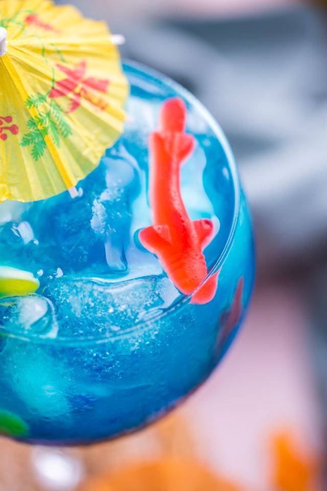 close up photo of the Fish Bowl Drink recipe with Swedish Fish candy from Ashley Rose of Sugar & Cloth