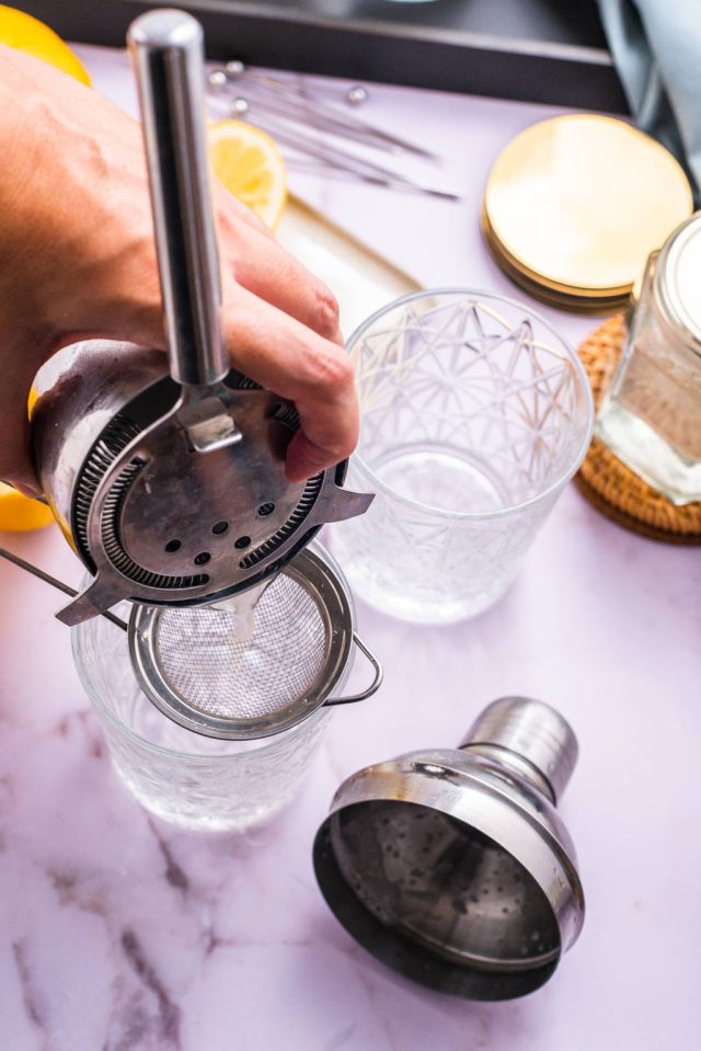 serving the cocktail while staining with a fine mesh strainer