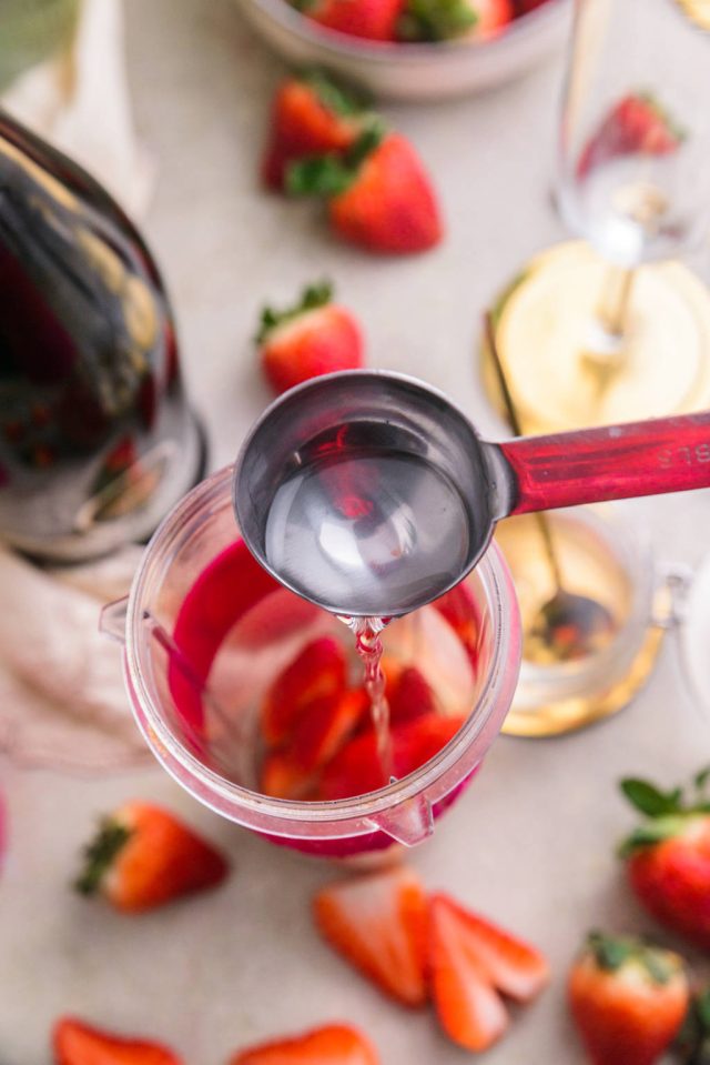 strawberries and adding syrup in a blender