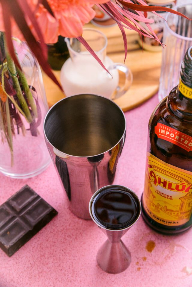 adding Kahlua to the cocktail shaker for the Mudslide 